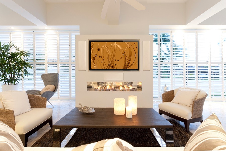 Well-lit living room accented by sophisticated and modern decor enhanced with elements of an audio-video installation.