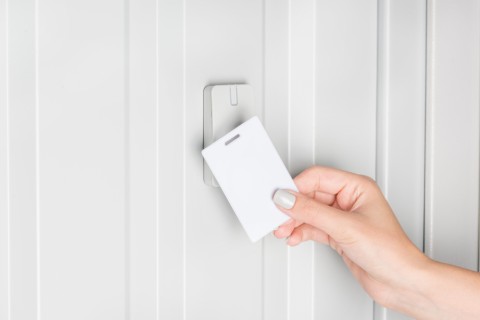 a person swiping a keycard on a card reader