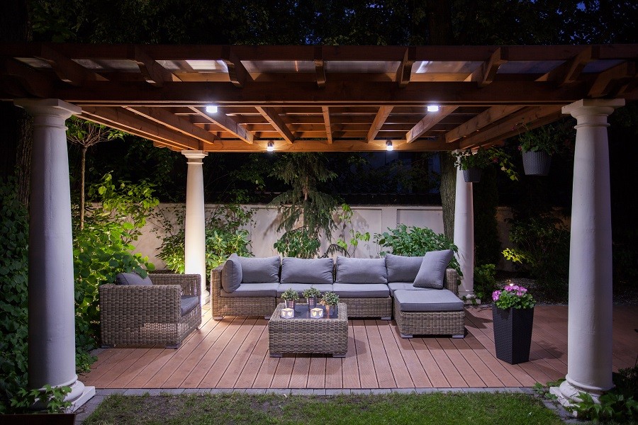 Stylish and comfortable outdoor patio with wicker furniture and dark wood lattice covering above. 