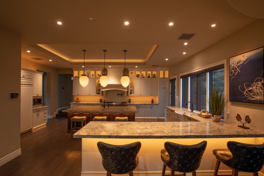 A kitchen with soft, warm lighting and expert lighting design, managed by Control4.