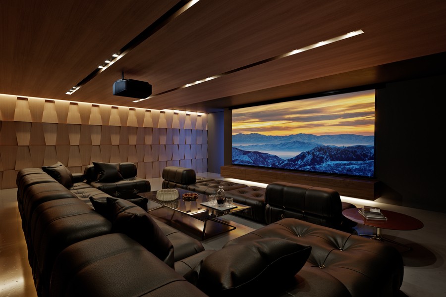 A home theater with a sectional with chaise lounges, acoustic paneling, large movie screen, and a Sony projector.