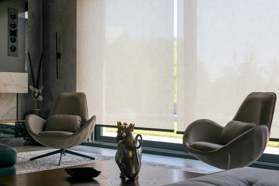 Image is of motorized blinds on the windows throughout a smart home.