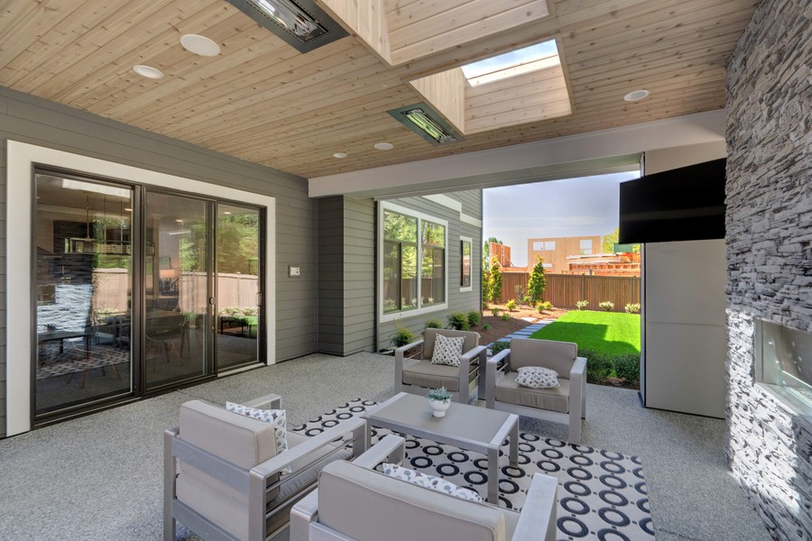 Image is of a modern smart home patio with AV systems installed.