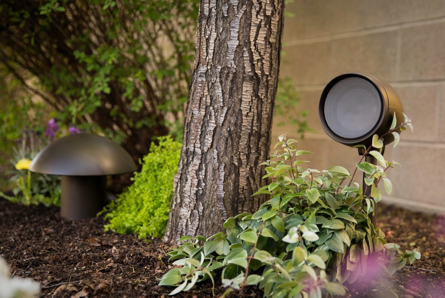 Triad outdoor speakers in a home garden.